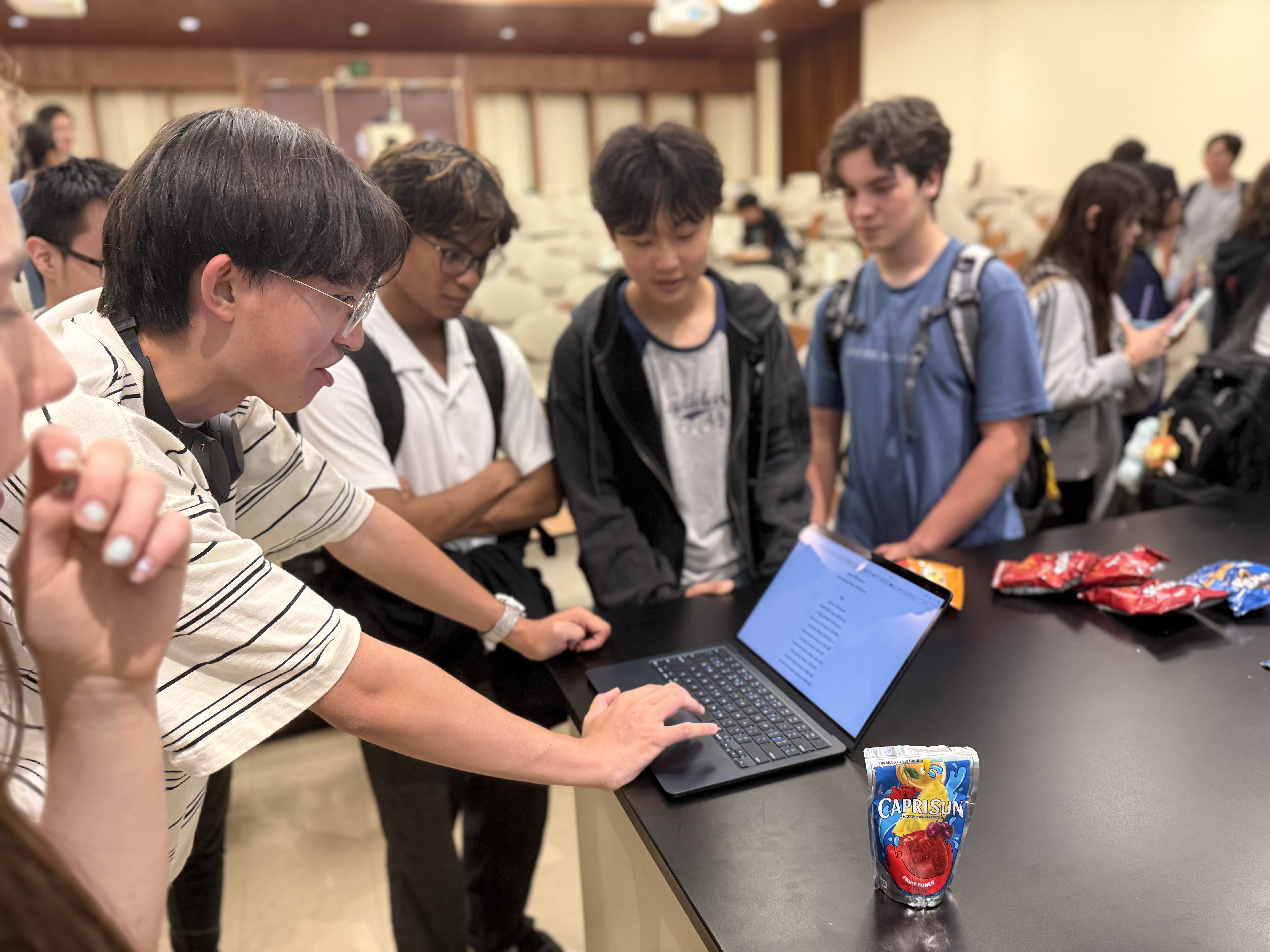 Students gather around a laptop