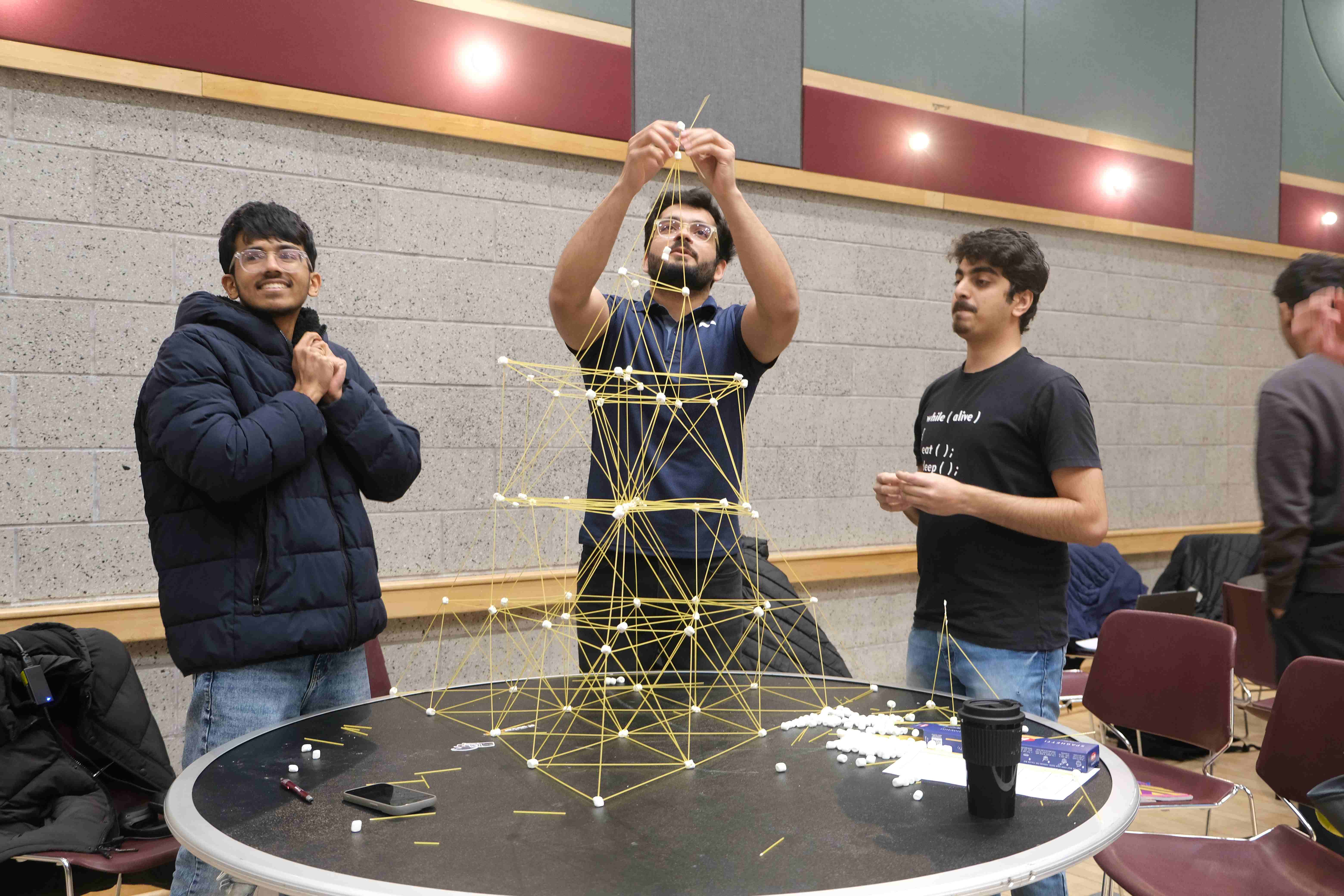 Students use spaghetti and marshmallows to build a structure