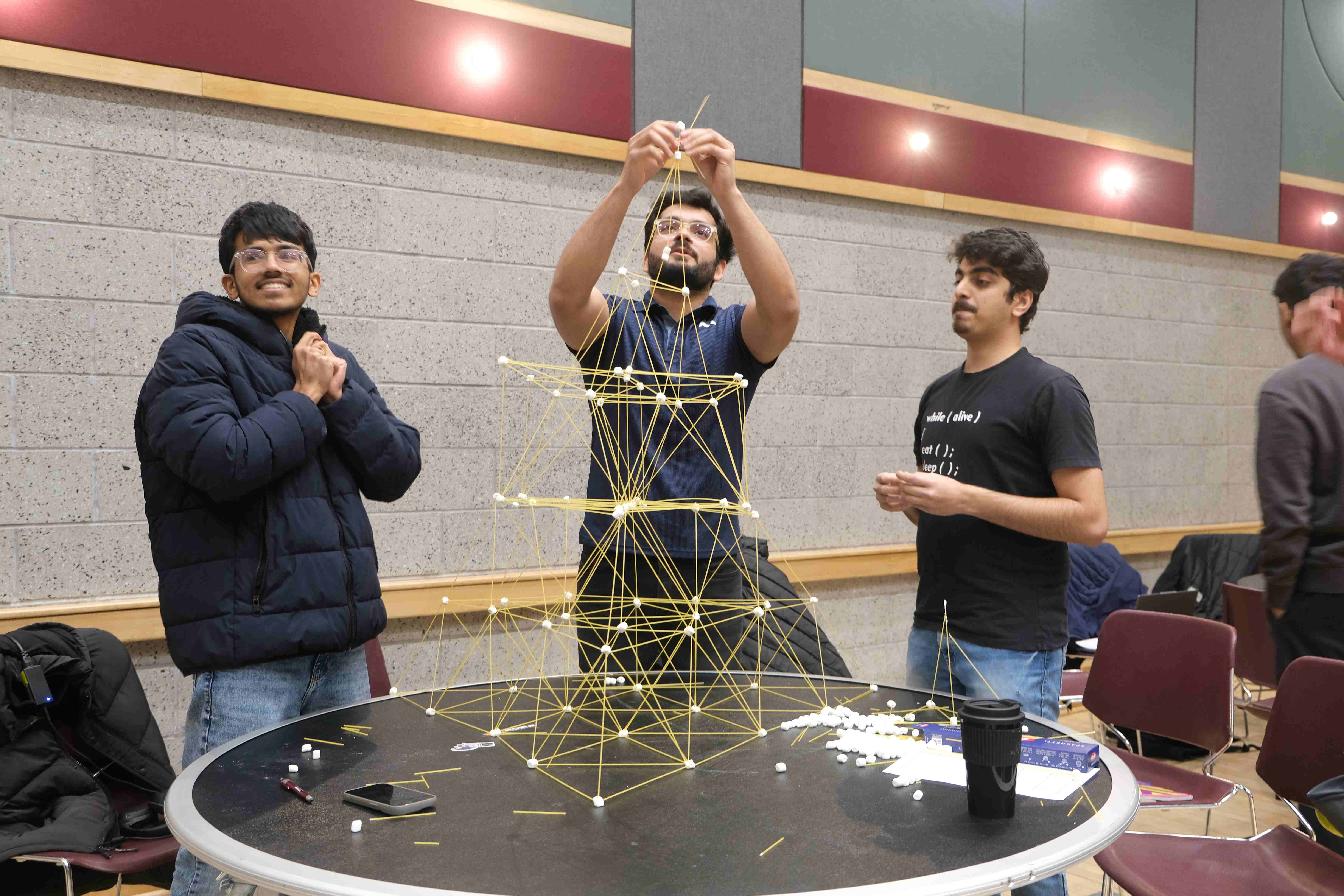 Students use spaghetti and marshmallows to build a structure Students use spaghetti and marshmallows to build a structure