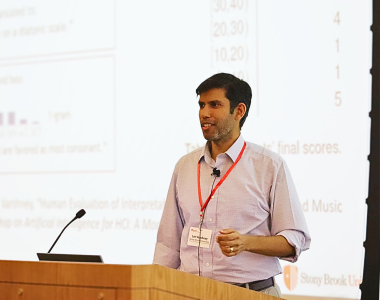 Lav Varshney stands behind a podium, giving a talk