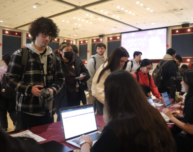 Students gather around a laptop