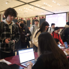 Students gather around a laptop